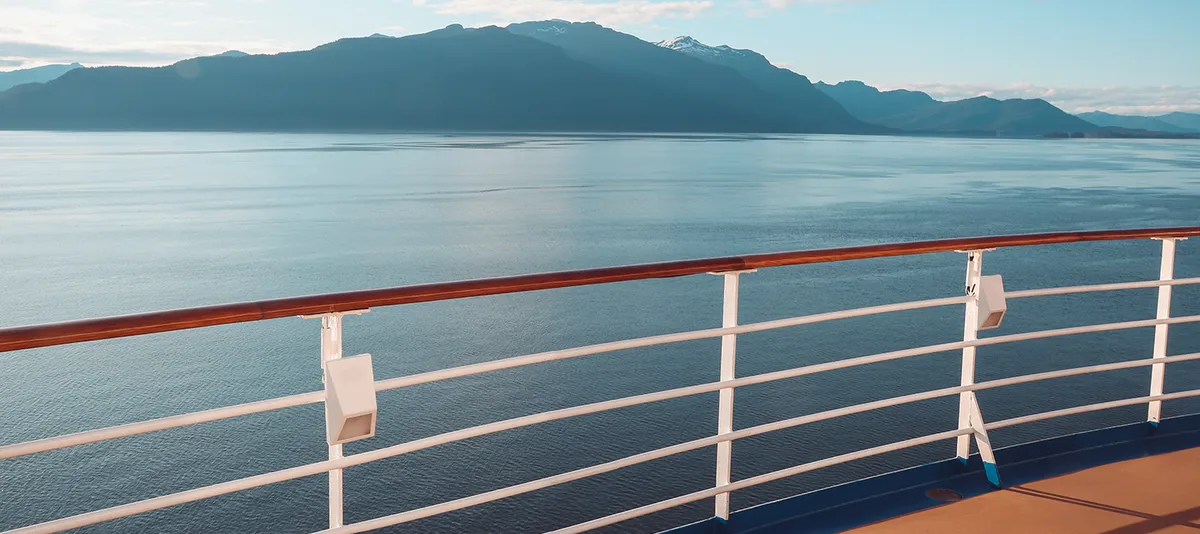 Der Blick auf das Meer und die Berge Alaskas vom Deck eines Kreuzfahrtschiffs