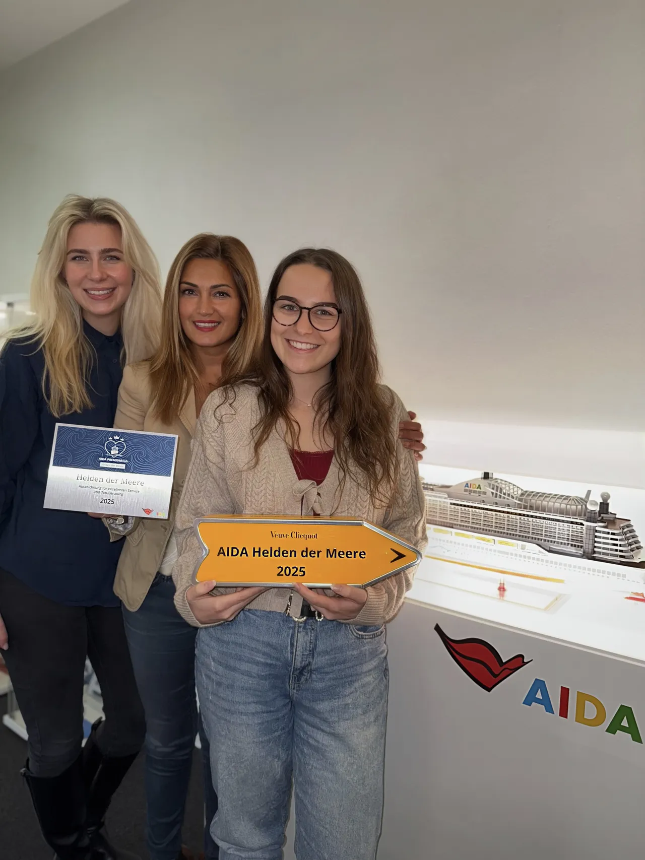 Drei Team-Mitglieder Team halten die beiden Awards - einer in Gelb und einer in Blau - Helden der Meere in der Hand