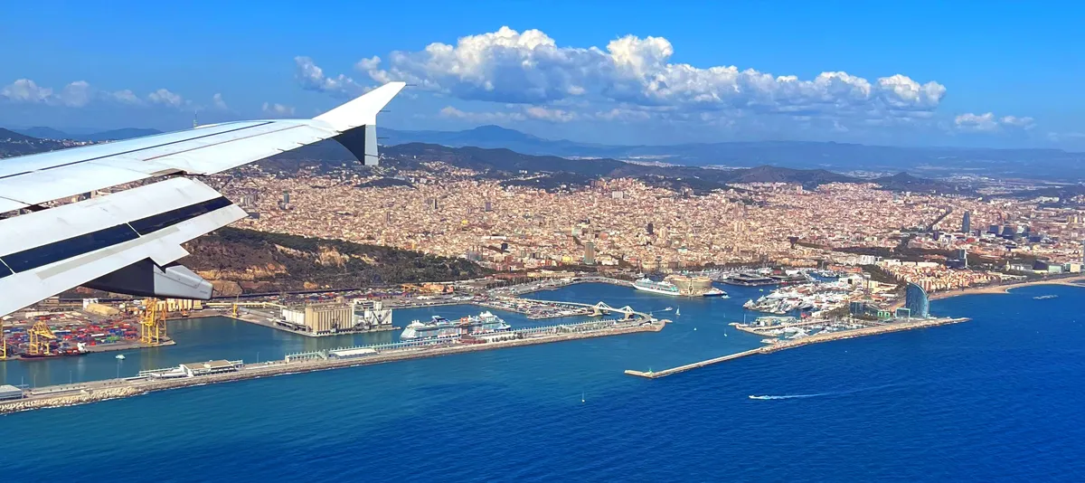 Landeanflug auf Barcelona mit Blick über den rechten Tragflügel über das Meer und den Hafen