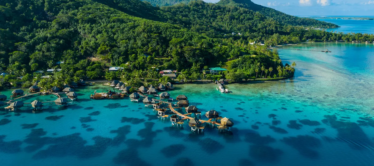 Blick auf das Moorea Atoll mit davor angeordneten Bungalows
