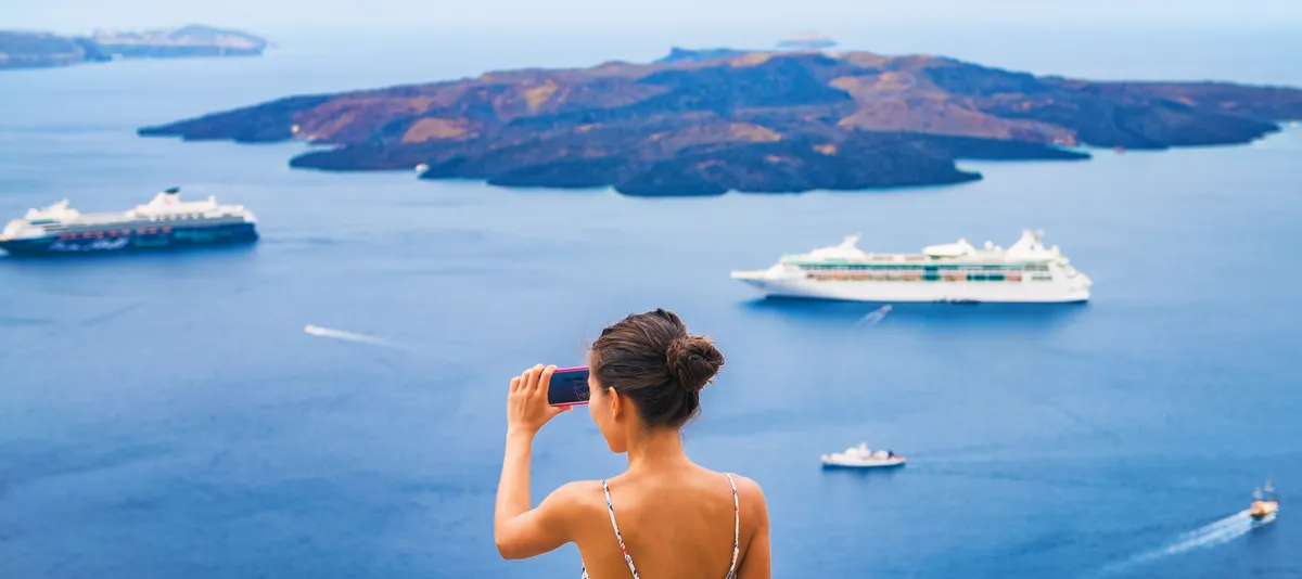 Frau macht Foto mit Smartphone vom Meer